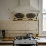 a slightly worn extractor fan mounted above a standard cooker